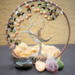this is the front view of an earthy colored tree of life. features include fluorite and wood beads accented with a crescent moon charm